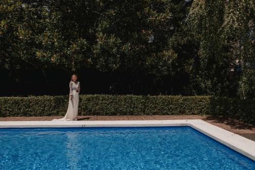 a woman in a wedding dress standing next to a swimming pool at Hotel Rio Bidasoa in Hondarribia