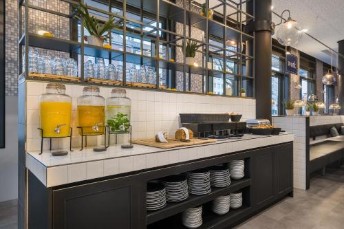 a restaurant with two glasses of orange juice and plates at Holiday Inn - the niu, Square Mannheim by IHG in Mannheim