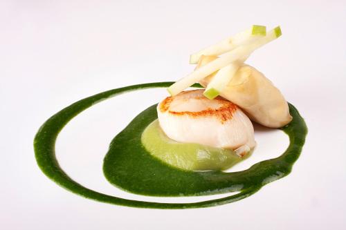 a piece of food on a plate with a green vegetable at Hotel Rio Bidasoa in Hondarribia