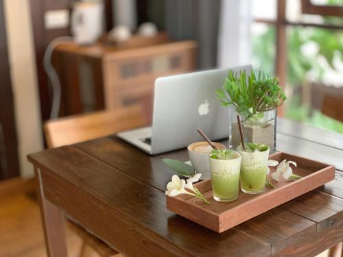 a wooden table with a laptop computer on top of it at Sand in My Shoes Beach Loft in Thong Nai Pan Noi