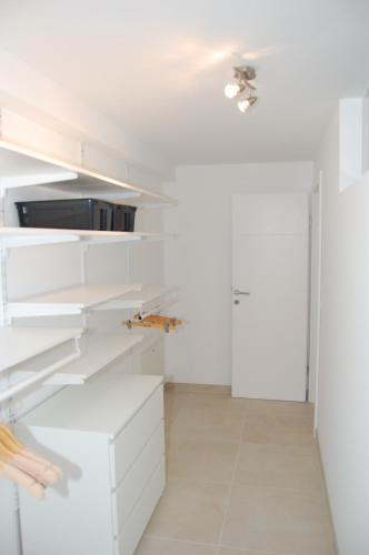 a white kitchen with white cabinets and a ceiling at WS-Appartement in Kitzbühel