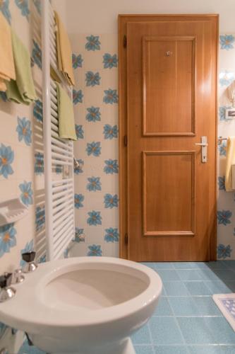 a bathroom with a white sink and a door at Garni La Vara in Corvara in Badia