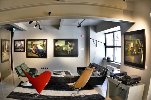 a living room with a red chair and a table at Raw Culture Art & Lofts Bairro Alto in Lisbon