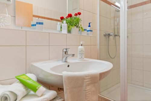 une salle de bain avec un lavabo et une douche dans l'établissement Strandvilla Alessandra, à Trassenheide