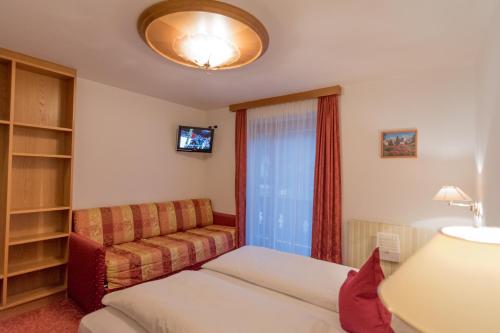a living room with a couch and a tv at Garni La Vara in Corvara in Badia