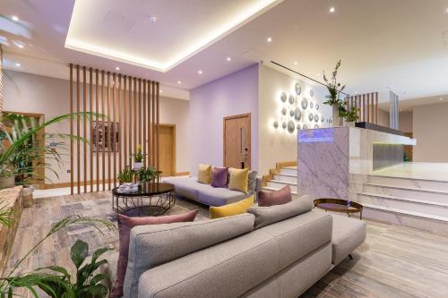 a living room with a couch and a table at Sanctum Belsize Road in London