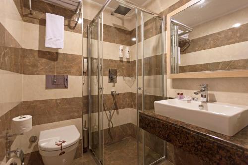 a bathroom with a sink and a toilet and a shower at Xperia Saray Beach Hotel in Alanya