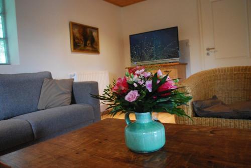 a vase of flowers on a table in a living room at Unter Eichen in Uplengen