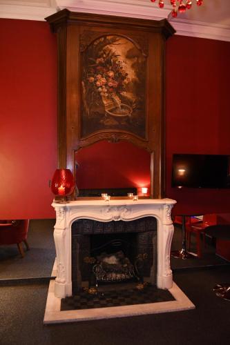 a fireplace in a room with a painting on the wall at Vip room 209 in Trooz