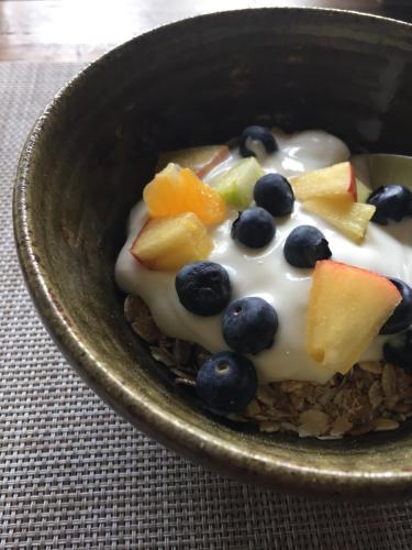 a bowl of food with fruit on top of granola at The Bridge House in Bridport