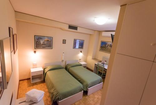 ein kleines Schlafzimmer mit 2 Betten in einem Zimmer in der Unterkunft Al Cavallino Bianco in Tricesimo
