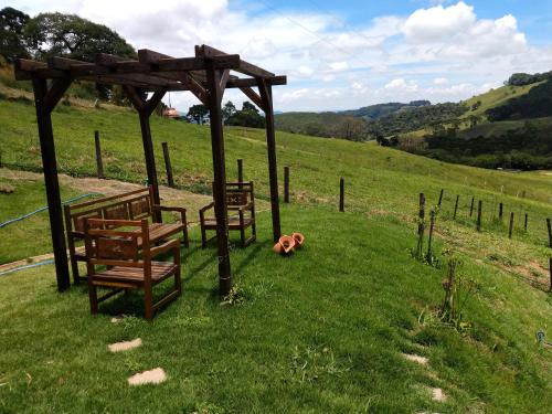 a group of benches sitting in the grass at Casa Vista da Lagoa in Gonçalves