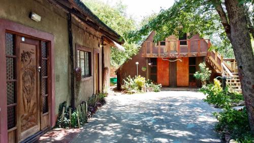 a courtyard of a house with a tree and a driveway at Elephant Trail Guesthouse and Backpackers in Kasane