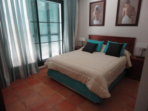 1 dormitorio con 1 cama grande con almohadas azules en Balcon de Sierra Cortina (Sea view), en Finestrat