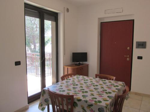 uma sala de jantar com uma mesa e cadeiras e uma janela em Appartamento dal marinaio Filippo em Metaponto