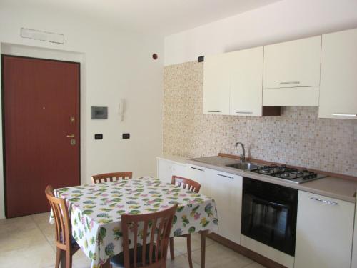 uma cozinha com uma mesa com cadeiras e um fogão em Appartamento dal marinaio Filippo em Metaponto