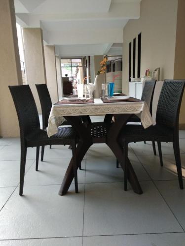 a dining room table with chairs and a tablecloth on it at Hotel Nirvana in Alibaug