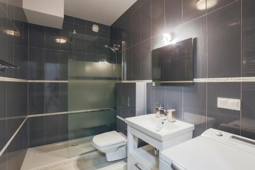 a bathroom with a sink and a toilet and a mirror at Apartament z widokiem na rzekę Gdańsk Stare Miasto in Gdańsk