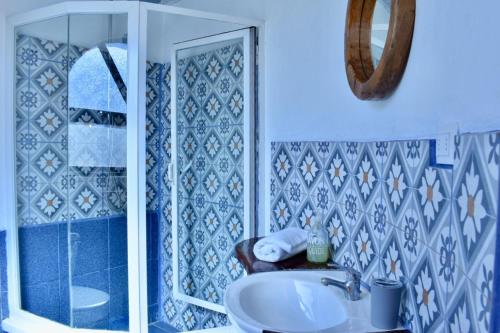ein blau-weißes Bad mit einem Waschbecken und einer Dusche in der Unterkunft Conviento de Lobos in Pichilemu