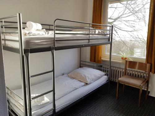 a bunk bed room with two bunk beds and a window at Berghotel in Bad Oeynhausen