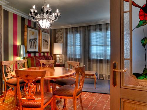 comedor con mesa, sillas y lámpara de araña en Casa Rural La Parra de Maribel, en Alquézar