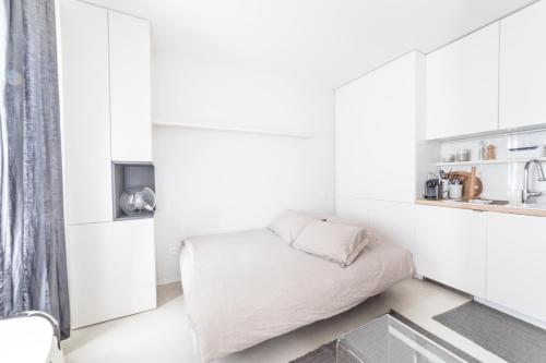 Cette petite chambre blanche comprend un lit. dans l'établissement Studio design Nuée bleue tout équipé centre ville, à Strasbourg