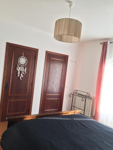 a bedroom with a bed and a wooden door at L'Escale au Portugal Villa-B&B-Spa in Ataíja de Baixo