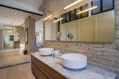 a bathroom with two sinks on a brick wall at Apartments Argemonia in Mali Lošinj