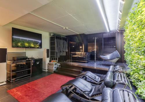 uma sala de estar com cadeiras de couro e uma televisão de ecrã plano em Apart Hotel Fulda em Fulda