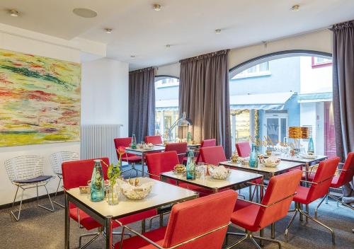 a restaurant with tables and chairs and a painting at Apart Hotel Fulda in Fulda