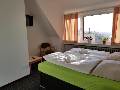 a bedroom with a large bed with a window at Berghotel in Bad Oeynhausen