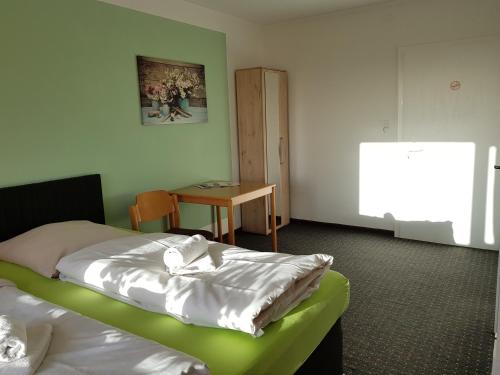 a room with two beds and a table in it at Berghotel in Bad Oeynhausen