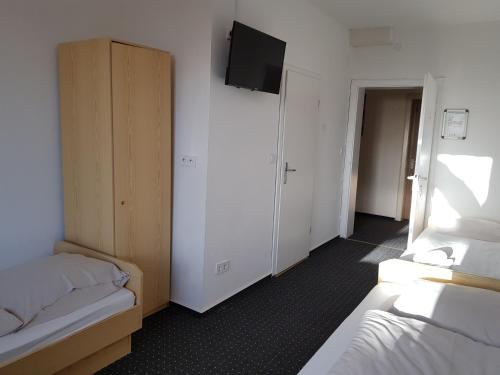 a room with two beds and a flat screen tv at Berghotel in Bad Oeynhausen
