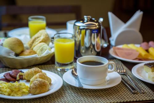a table with plates of breakfast foods and a cup of coffee at Intercity Manaus in Manaus