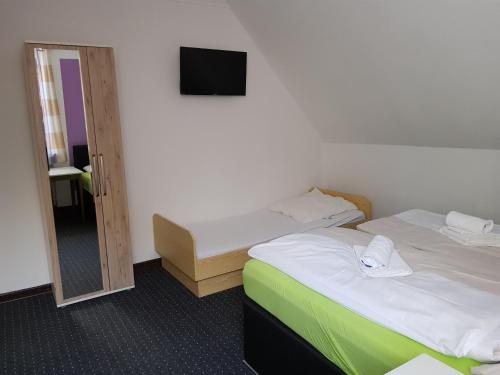 a hotel room with two beds and a mirror at Berghotel in Bad Oeynhausen