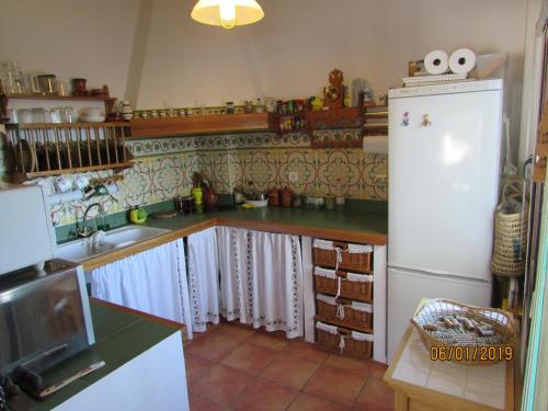 a kitchen with a white refrigerator and a sink at CALLE CALVARIO 10 in Zufre