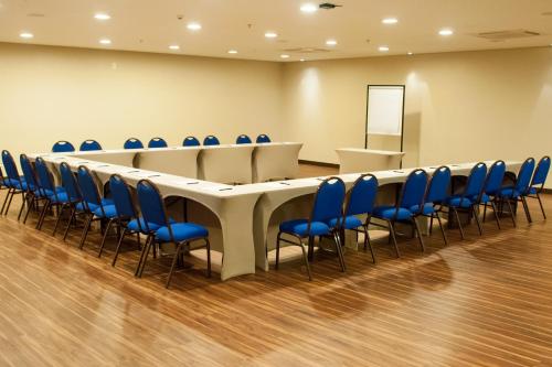 a conference room with a long table and blue chairs at Intercity Manaus in Manaus