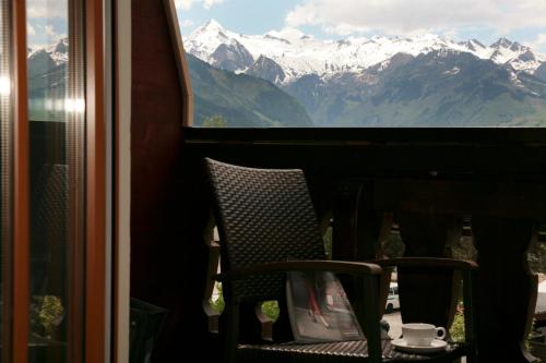 a chair in a window with a view of mountains at Edelweiss am See in Zell am See
