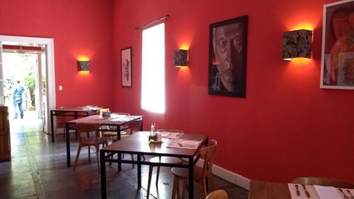 a restaurant with red walls and wooden tables and chairs at Hotel Plaza Malloa in Malloa