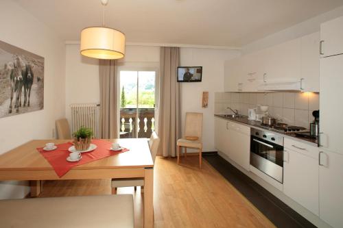 a kitchen with a table and a dining room at Edelweiss am See in Zell am See