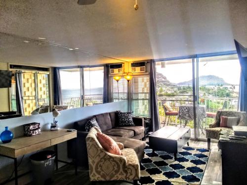 a living room with a couch and a table at Pokai Bay Penthouse Studio in Waianae