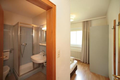a bathroom with a sink and a shower and a toilet at Edelweiss am See in Zell am See