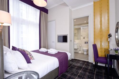 a hotel room with a bed and a bathroom at Destiny Scotland Charlotte Square Apartments in Edinburgh