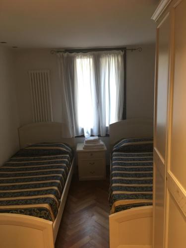 two beds in a small room with a window at Appartamenti Ghetto Vecio in Venice