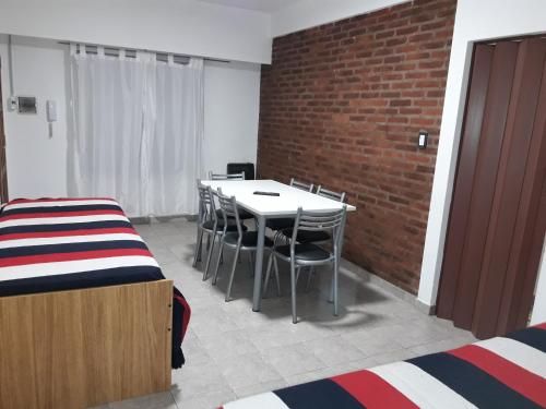 a room with a table and chairs and a brick wall at Apartamento céntrico 19 de Mayo 2 con cochera in Bahía Blanca