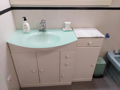 a bathroom with a sink with a soap dispenser on it at Villa con piscina privada in Torremolinos