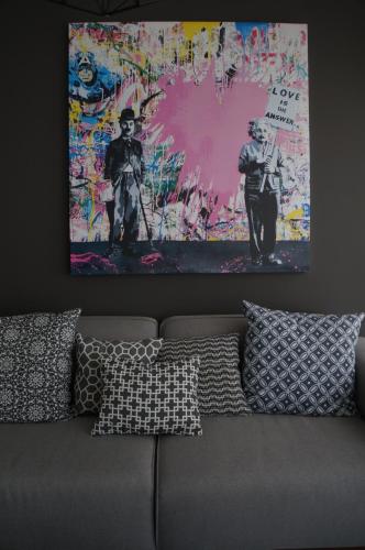 a painting on the wall above a couch with pillows at Metropolitan Suites in Guadalajara