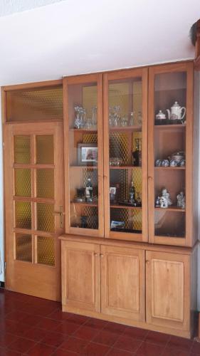 a wooden cabinet with glass doors in a room at Apartments Judit in Tar