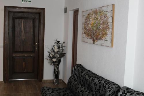 a living room with a couch and a vase of flowers at Къща за гости Мишурови in Smolyan