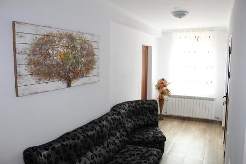 a living room with a couch and a painting on the wall at Къща за гости Мишурови in Smolyan